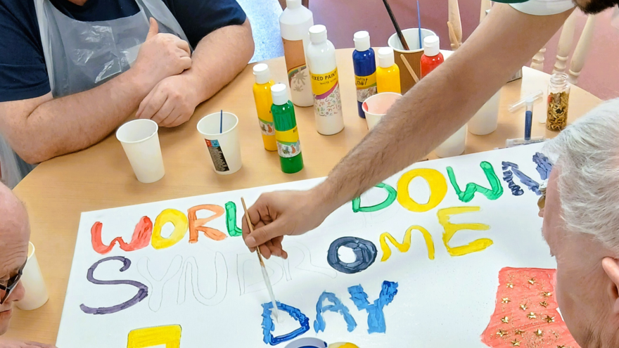People painting a World Down Syndrome Day poster 
