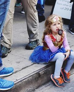 Girl sitting on a step dressed as wonder woman